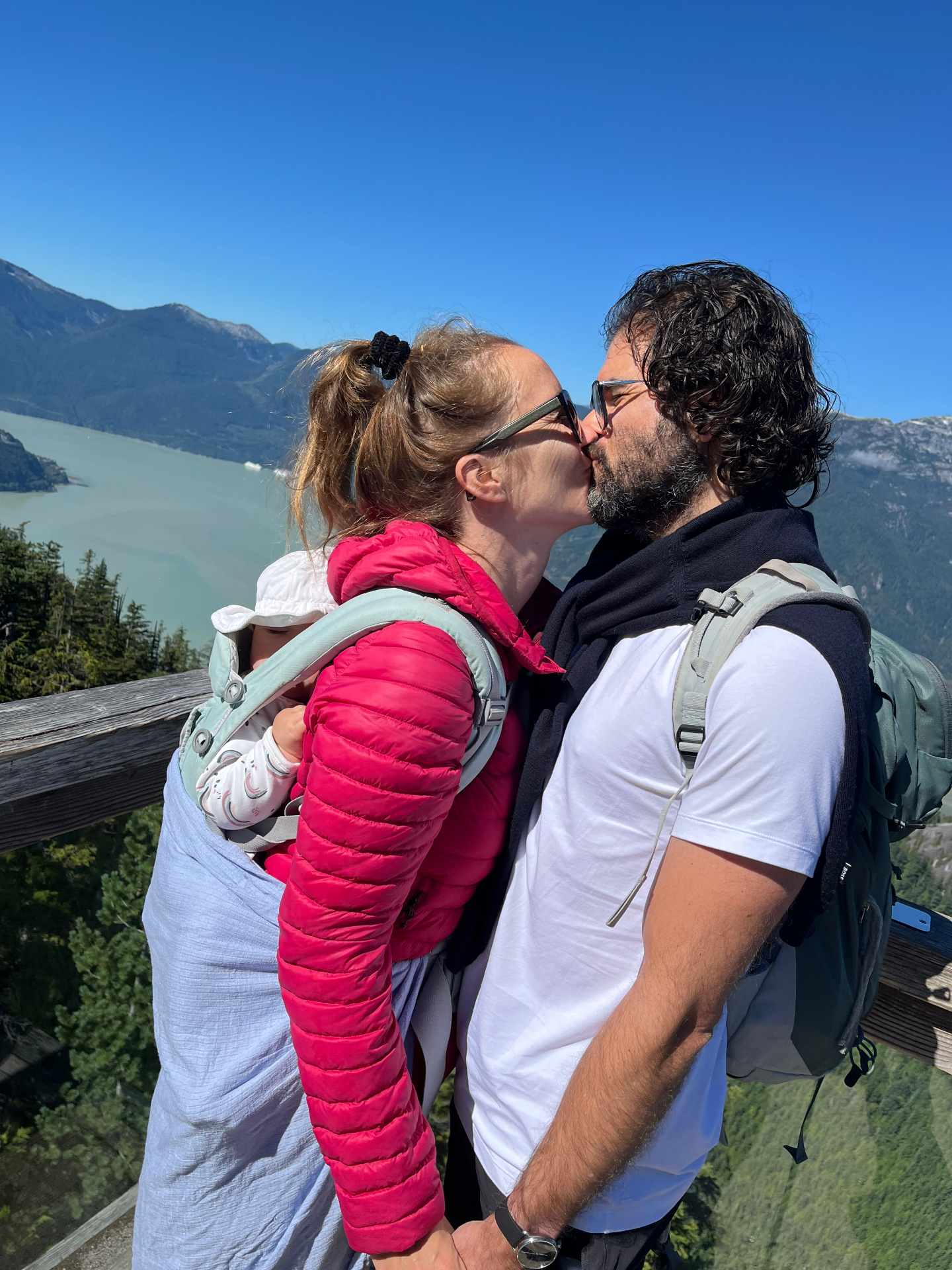 A family outdoors overlooking mountains and water